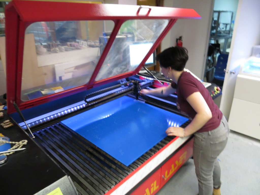 Lauren loads my sheet of acrylic into the laser cutter.